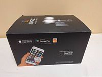 Box front showing Bazz Smart Home branding, image of security light with dual LED lights and camera, and app store compatibility logos.