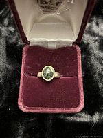 Front view of the ring showing the green malachite stone set in sterling silver with a velvet ring box