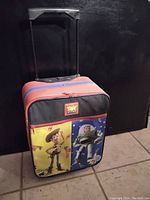 Front view of wheeled suitcase featuring Woody and Buzz Lightyear graphics.