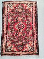 Full view of the rectangular Persian Hamedan rug showing flower pattern in subdued colors and traditional border motifs.