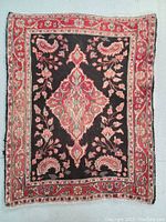 Full view of the Persian Tabriz wool rug showing the central floral medallion and the floral and paisley border on black and red background.
