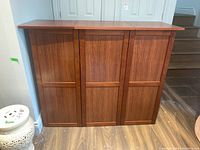 Front view showing the three-panel door design and wood grain finish.