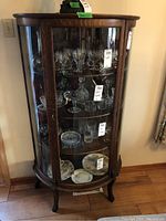 Front view showing oak frame and two curved glass doors with three interior glass shelves