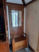 Full front view of oak hall tree showing mirror, hooks, seat closed