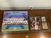 Pat Borders plaque and 1993 Toronto Blue Jays World Series poster laid side by side on a wooden table.