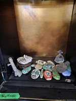 Group of small porcelain and ceramic snuff bottles with one glass perfume bottle on shelf