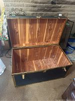 Open trunk showing full cedar lined interior with natural wood grain and knots. Interior appears clean with some scratches.