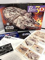 Photo of the puzzle box, showing front with Millennium Falcon 3-D image, instruction booklet, and puzzle pieces inside.