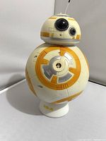 Front view of the BB-8 bubble blower showing the spherical body with orange and gray details and the base stand with BB-8 inscription.