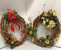 Pair of two round decorative vine wreaths with holiday accents against a white background