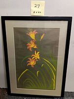 Full view of framed lithograph artwork showing day lilies with black frame and matting. Post-it note showing '27 16x22' measurements is visible.