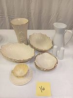 Full lot view showing various pottery pieces including Belleek teacup and saucer, Lenox bowls, vase, and Rosenthal pitcher with salt and pepper shakers.