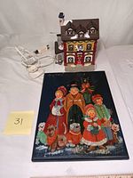 Christmas village butcher shop decoration with light power cord, snow-capped roof, and red and yellow facade.