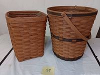 Front view of two baskets, one rectangular and one round with handle