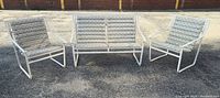 Front view of the 3-piece vintage patio furniture set with two chairs and one bench, all with white metal frames and floral upholstered cushions.