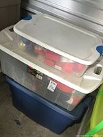Stacked plastic storage totes containing Christmas decorations