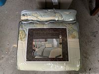 Packaged queen comforter ensemble in clear zippered storage bag showing a photo of the bedding set arranged on a bed with floral pattern in soft greens and creams.