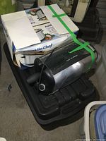 Boxed Franklin Chef slow cooker and stainless steel rotisserie appliance on top of black tote.