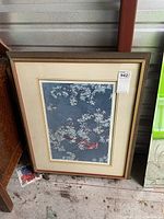 Full view of framed print leaning against storage unit wall