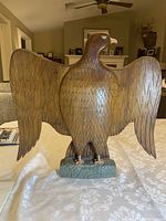 Front view of hand carved wooden eagle sculpture with wings spread wide and detailed feather carving.