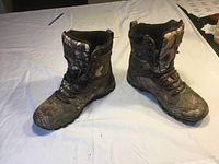 Pair of men's camouflage hiking boots on white surface, showing overall design and size.