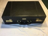 Top view of black leather Samsonite briefcase with subtle stitched design and central handle.