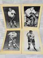 Four black-and-white photographs each showing a Chicago Black Hawks player in 1950s hockey uniform with player name noted, mounted on card backing