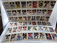 Photo showing multiple rows of hockey cards laid out, displaying the set in protective sleeves with players in various team jerseys.