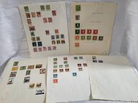Five album pages each with multiple vintage postage stamps in various colors and denominations arranged in rows.