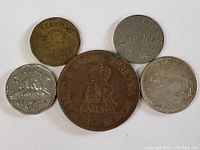Top view of 5 Canadian coins showing different metals and designs including a commemorative coronation plaque and dated coins.