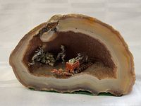 Front view of the geode cross-section showing the mining diorama inside with two miner figurines and a mining cart on tracks.