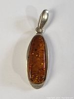 Full front view of the amber pendant set in sterling silver.