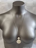 Full view of necklace on mannequin bust showing pendant and chain length.