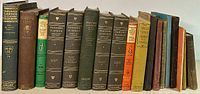 Front view of 15 antique books arranged in a row showing spines in varied conditions and colors for identification.