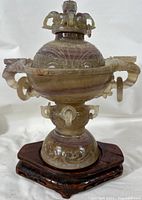 Front view of tourmaline censer on wooden stand showing overall shape and color banding