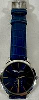 Full view of blue leather strap and watch face from the front with visible buckle.