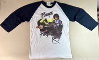 Full front view of the vintage 1983 Prince Purple Rain raglan T-shirt with black 3/4 length sleeves and white body.