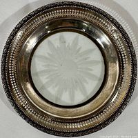 Top view of the vintage Frank Whiting champagne coaster showing the sterling silver rim with intricate patterns and the clear crystal starburst center.