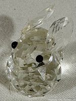 Front view of clear multi-faceted Swarovski crystal rabbit with black eyes and signed base.