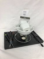 Photo showing the entire chocolate fondue set including bowl, stand, base tray, four forks, and spoon arranged neatly for display.