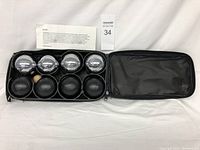 Photo showing all bocce balls and pallino in a black carrying case, with instruction sheet included.