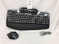 Ergonomic Logitech wireless keyboard with wrist rest, wireless mouse, USB wireless receiver dongle, and battery pack shown on a white background.