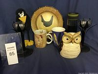 Full collection view with platter, mugs, wooden crow, ceramic owl, candle sticks and Contigo mug