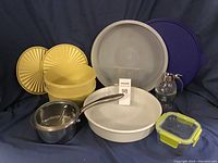 Full view of all items including Tupperware, saucepan, storage container, pie pan, honey dispenser, and lids