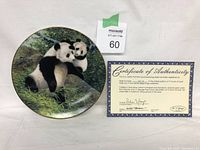 Collector's plate featuring two pandas and certificate of authenticity side by side on a white background.