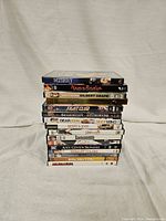 Stack of 16 DVDs mostly from the 1990s shown with titles on spines in clear view.