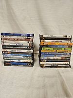 Photo showing two stacks of DVD cases arranged side by side, titles readable, showcasing the entire lot of 28 DVDs.