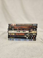 Photo showing a stacked set of eight horror DVDs with visible titles: Jack Brooks Monster Slayer, Rosemary's Baby, The Eye, The Grudge, The Exorcist and The Ring.