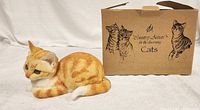 Orange and white realistic cat figure with box in background labeled 'Country Artists of the Harmony Cats'
