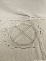 Top view of the clear glass divided dish showing scalloped edges and handles.